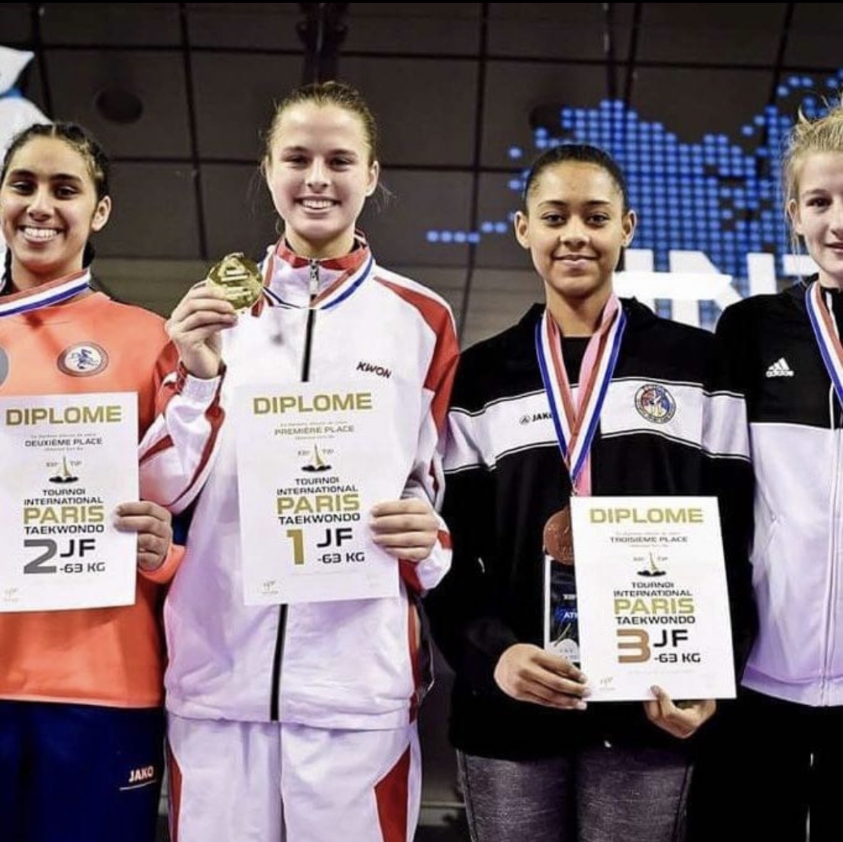 Andrea holding a gold medal and first-place diploma