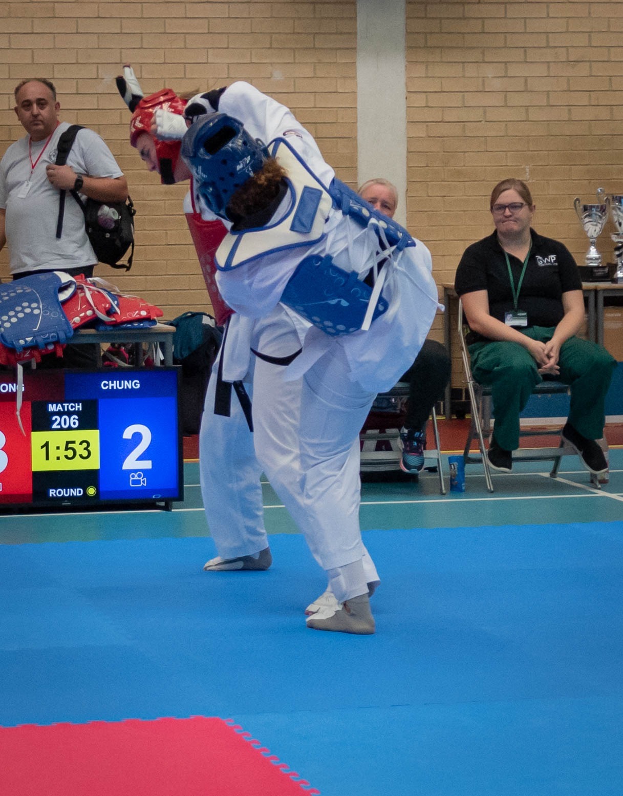 Andrea landing a spinning kick at a taekwondo competition