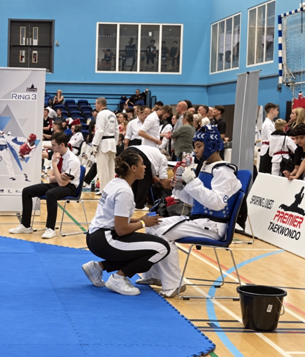 Andrea coaching a young taekwondo athlete ringside